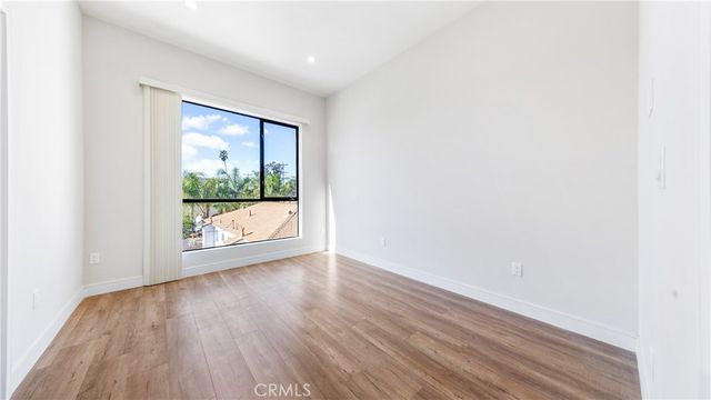 a view of a room with wooden floor and a window