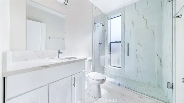 a bathroom with a sink toilet a mirror and shower