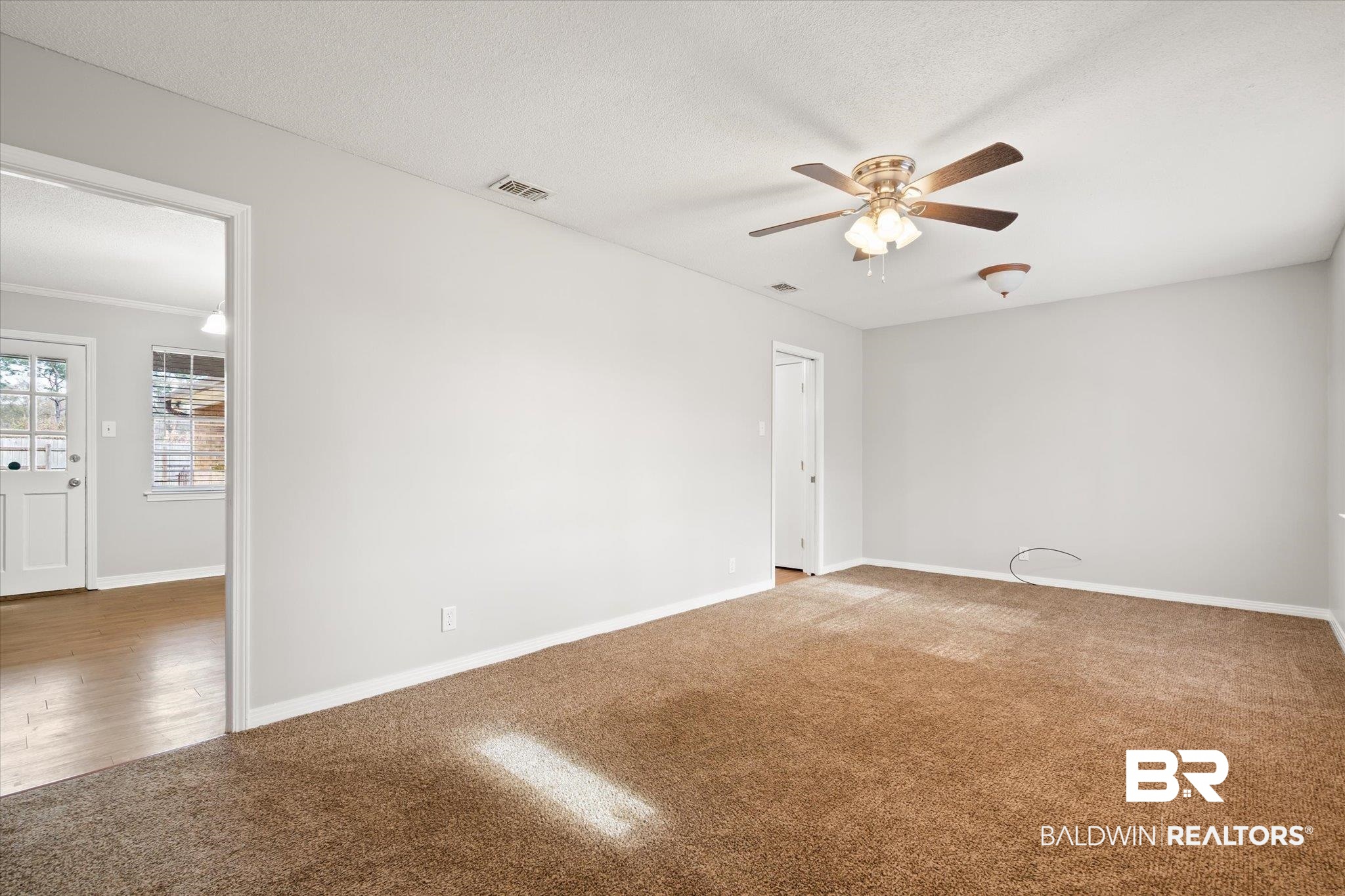 6848 Sandra Drive Theodore, AL 36582 - Photo 15 of 21 Carpeted spare room featuring ceiling fan and a textured ceiling