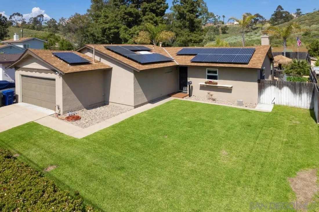a view of a house with a yard porch and wooden fence