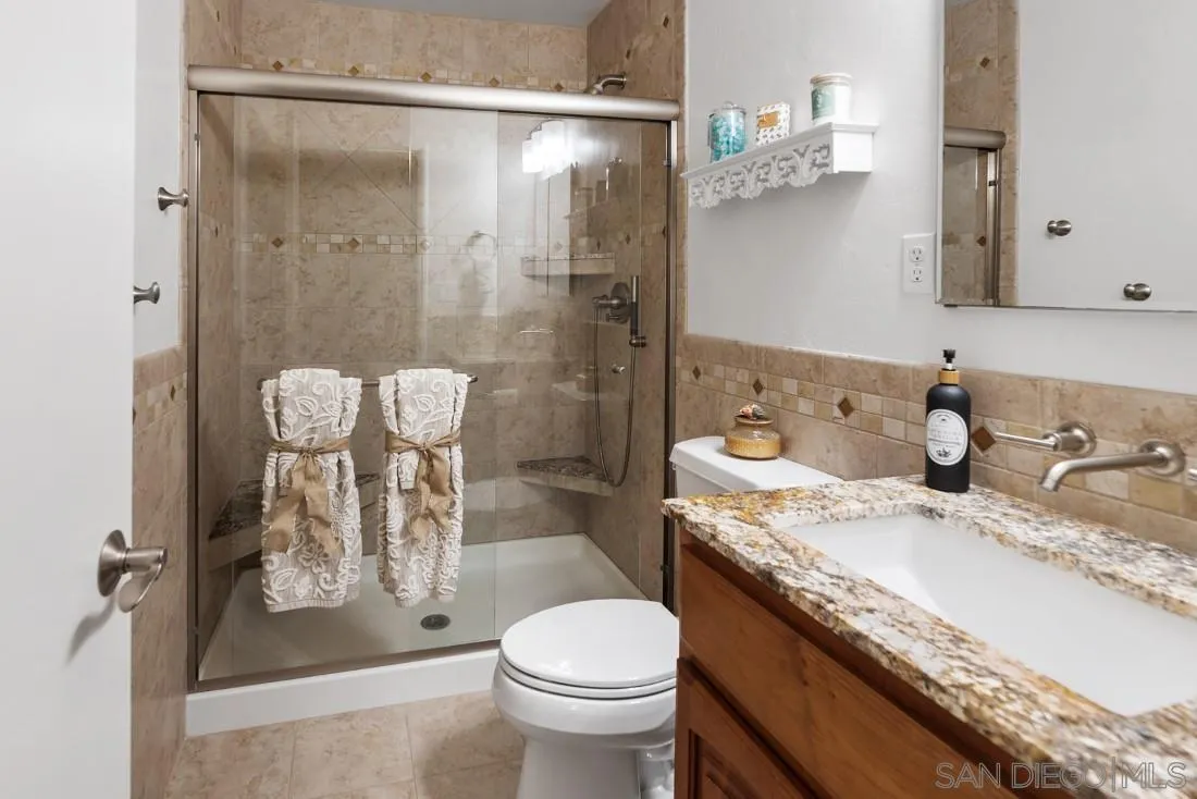 13829 Tobiasson Road Poway, CA 92064 - Photo 22 of 52 a bathroom with a granite countertop sink a toilet and shower