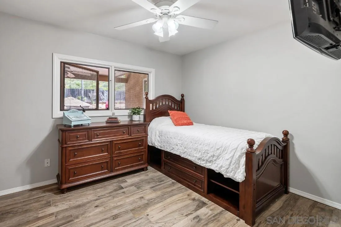 13829 Tobiasson Road Poway, CA 92064 - Photo 23 of 52 a bedroom with a bed and a large window with wooden floor