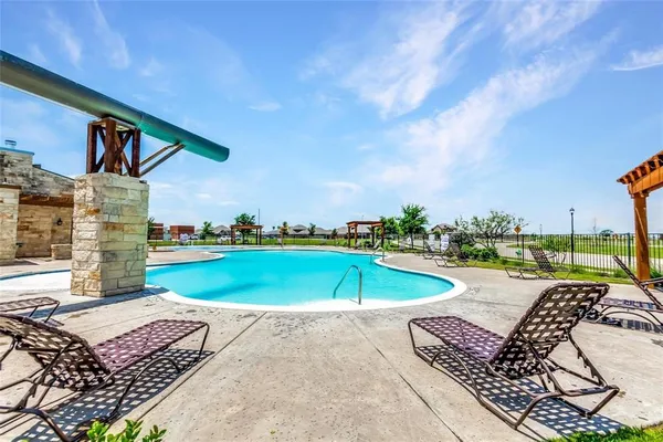 an outdoor space with swimming pool and furniture