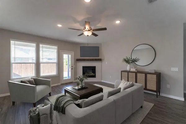 a living room with furniture two window and a fireplace