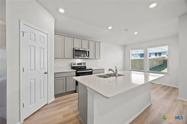 a kitchen with sink a microwave and refrigerator