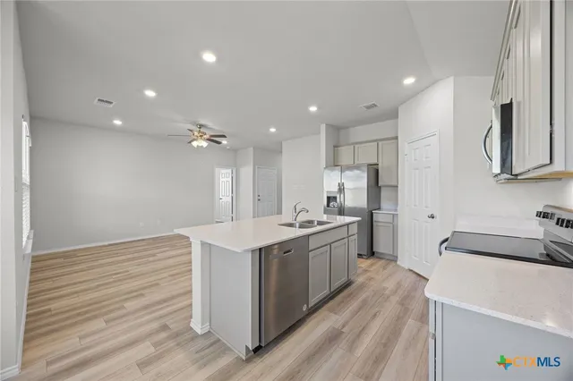 a large kitchen with kitchen island a sink stainless steel appliances and cabinets