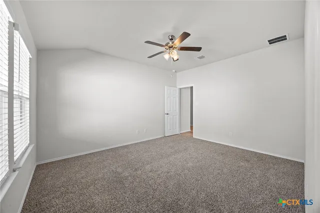 a view of room with a ceiling fan and window