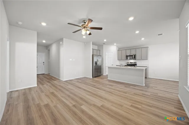 a view of kitchen with refrigerator microwave and stove