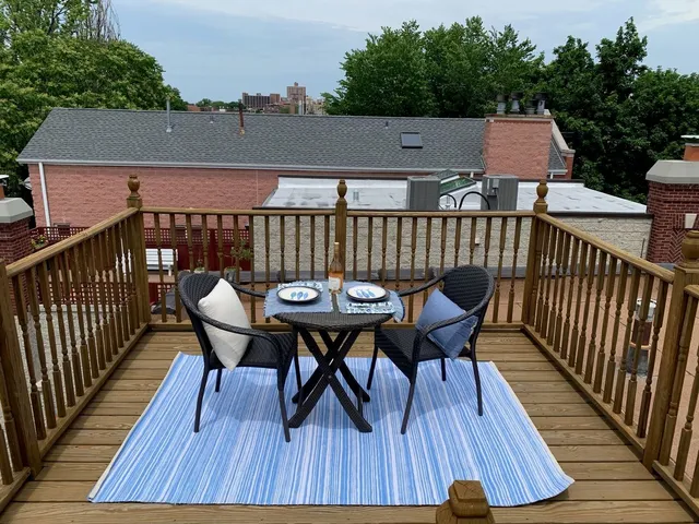 a view of deck with table and chairs a barbeque with wooden floor and fence