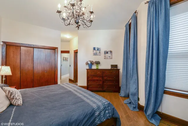 a bedroom with a bed and a chandelier