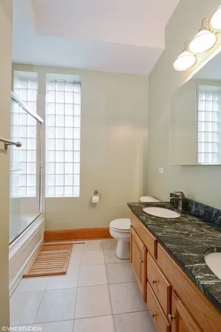 a bathroom with a granite countertop sink a toilet and a bathtub