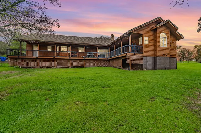 a view of a house with a yard and sitting area