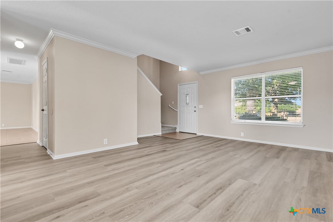 172 Coreopsis Cove Kyle, TX 78640 - Photo 12 of 33 an empty room with wooden floor and windows