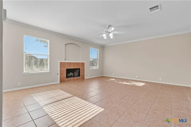 a view of empty room with a fireplace and fan