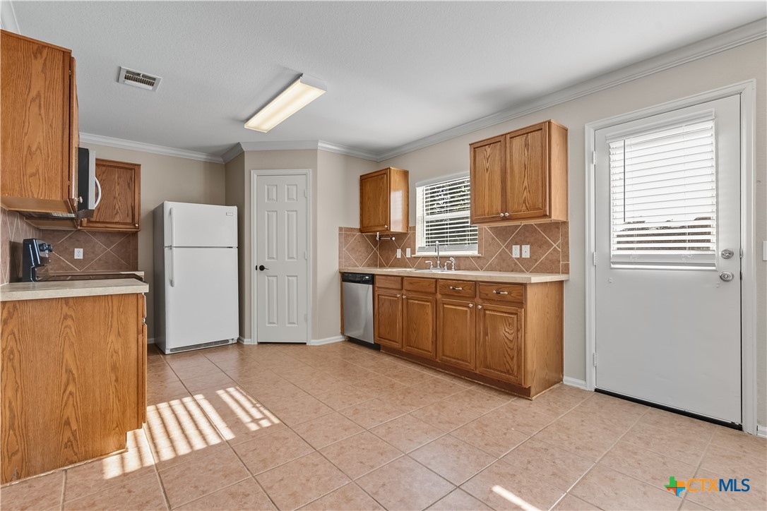172 Coreopsis Cove Kyle, TX 78640 - Photo 18 of 33 a kitchen with a sink a stove and cabinets