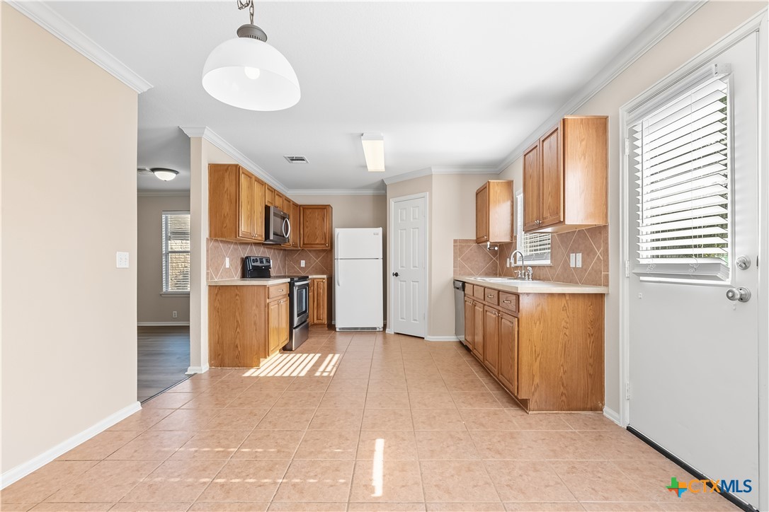 172 Coreopsis Cove Kyle, TX 78640 - Photo 19 of 33 a kitchen with refrigerator cabinets and a sink