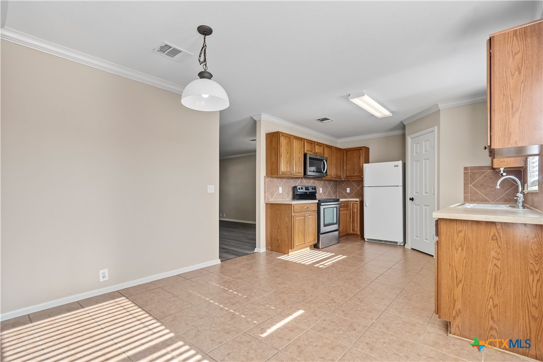 172 Coreopsis Cove Kyle, TX 78640 - Photo 21 of 33 a view of kitchen with sink microwave refrigerator and cabinets