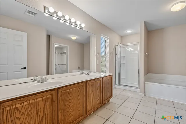 a bathroom with a tub a sink and mirror