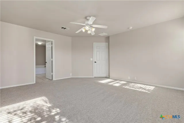 an empty room with an entryway and fan