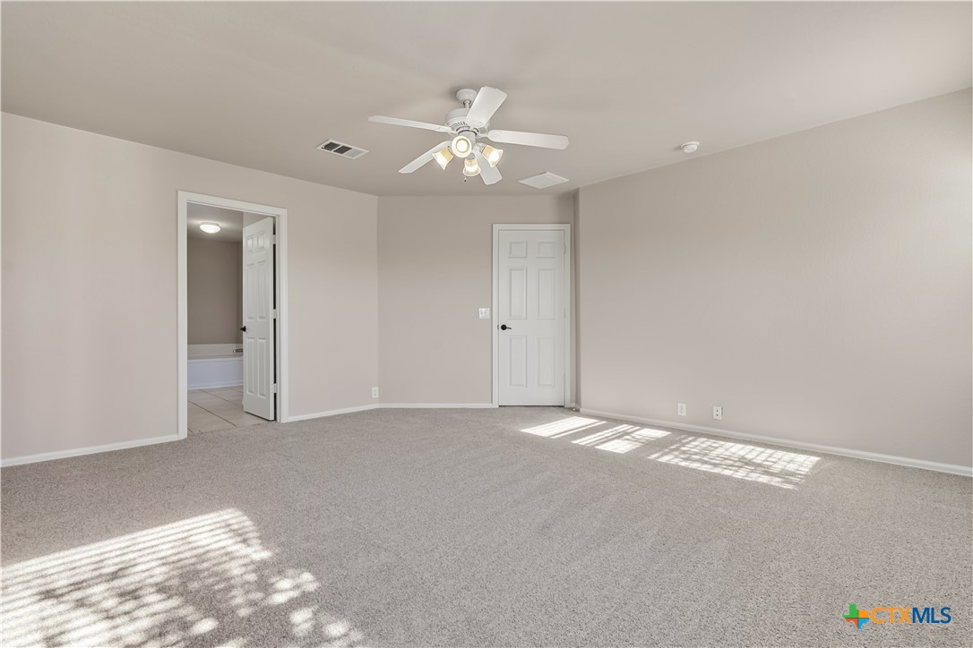 172 Coreopsis Cove Kyle, TX 78640 - Photo 7 of 33 an empty room with an entryway and fan