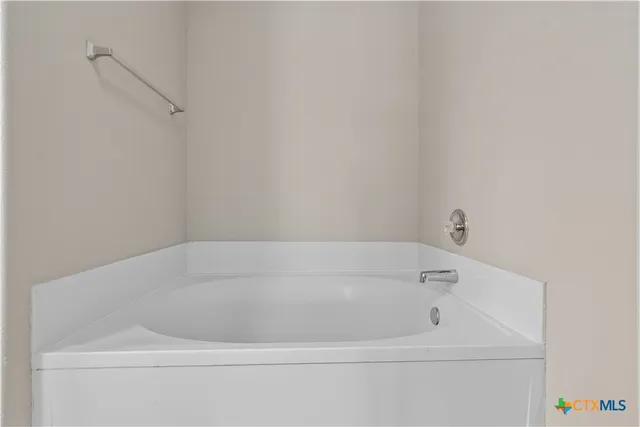 a white bath tub sitting next to a white sink and vanity