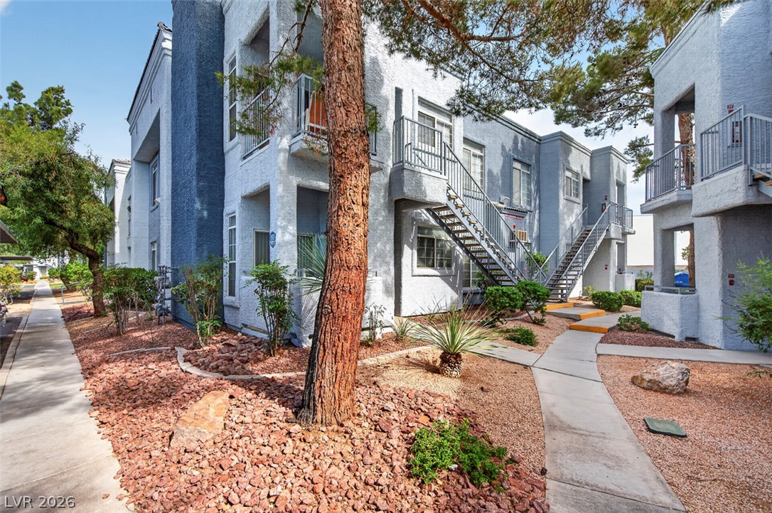 2201 Ramsgate Drive, Unit 1011 Henderson, NV 89074 - Photo 2 of 40 A neatly landscaped communal area with pathways connecting multiple apartment buildings under a clear sky.