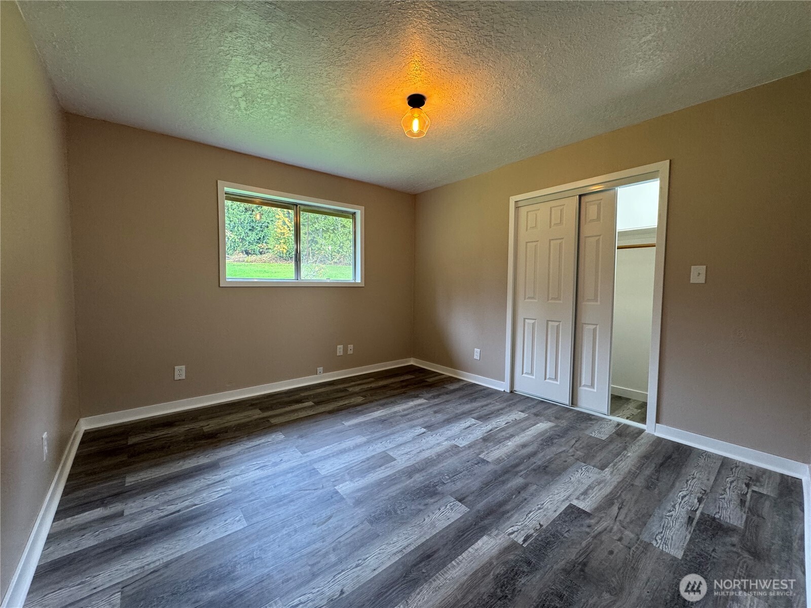 212 McGeary Road Kelso, WA 98626 - Photo 9 of 20 an empty room with wooden floor and windows