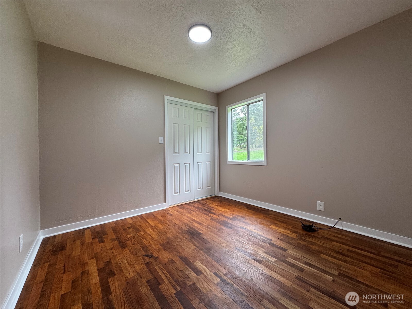 212 McGeary Road Kelso, WA 98626 - Photo 10 of 20 an empty room with wooden floor and windows