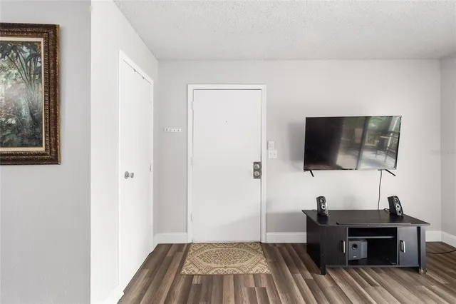 a view of a livingroom with a flat screen tv wooden floor and a window