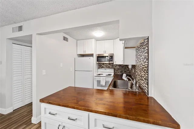 a kitchen with kitchen island a sink appliances and cabinets