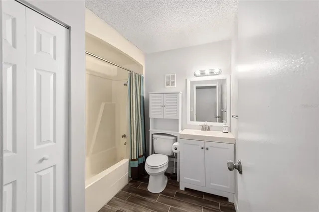 a bathroom with a toilet sink a mirror a vanity and shower
