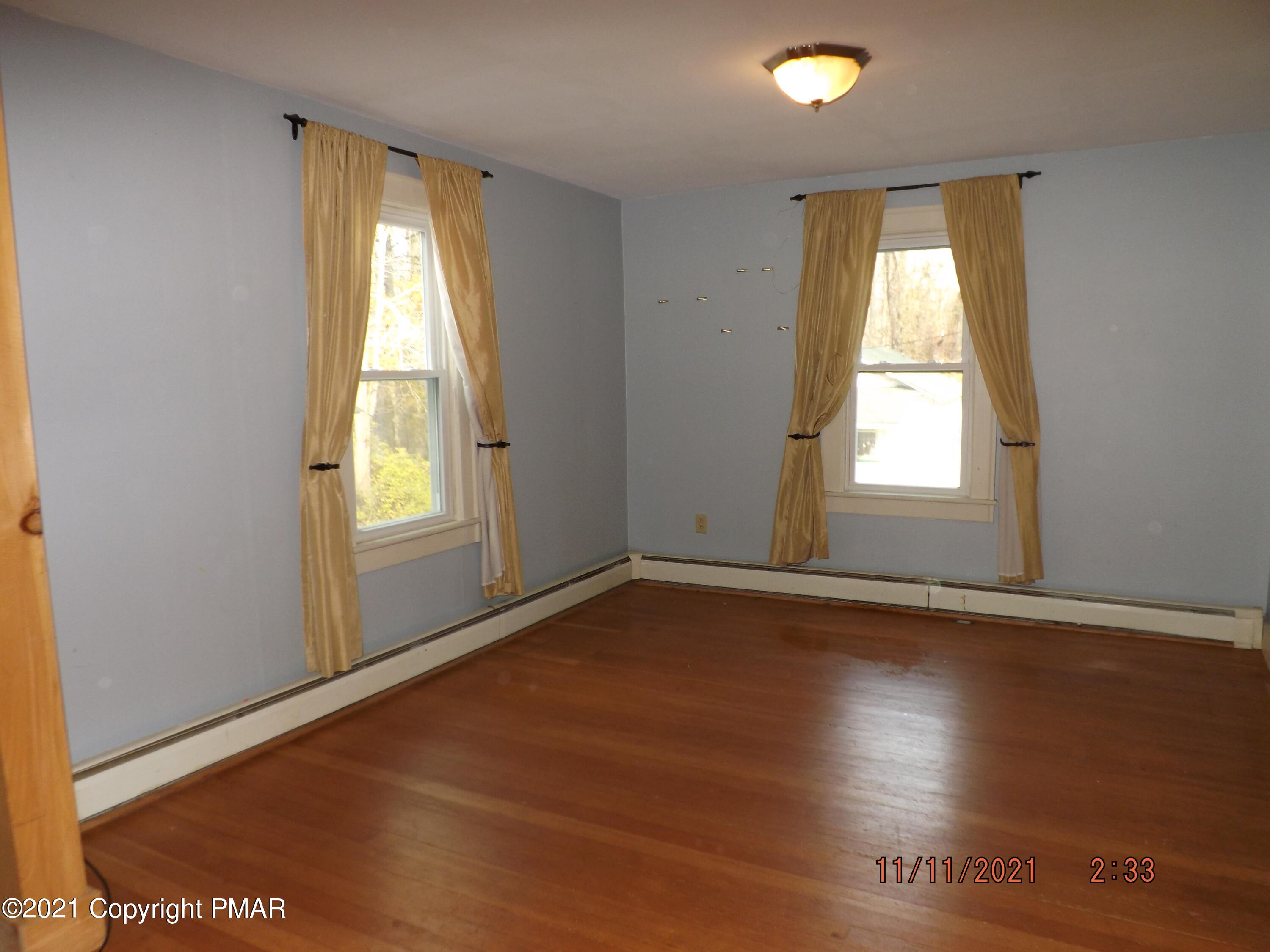 5474 Paradise Valley Road Cresco, PA 18326 - Photo 14 of 34 an empty room with wooden floor and windows