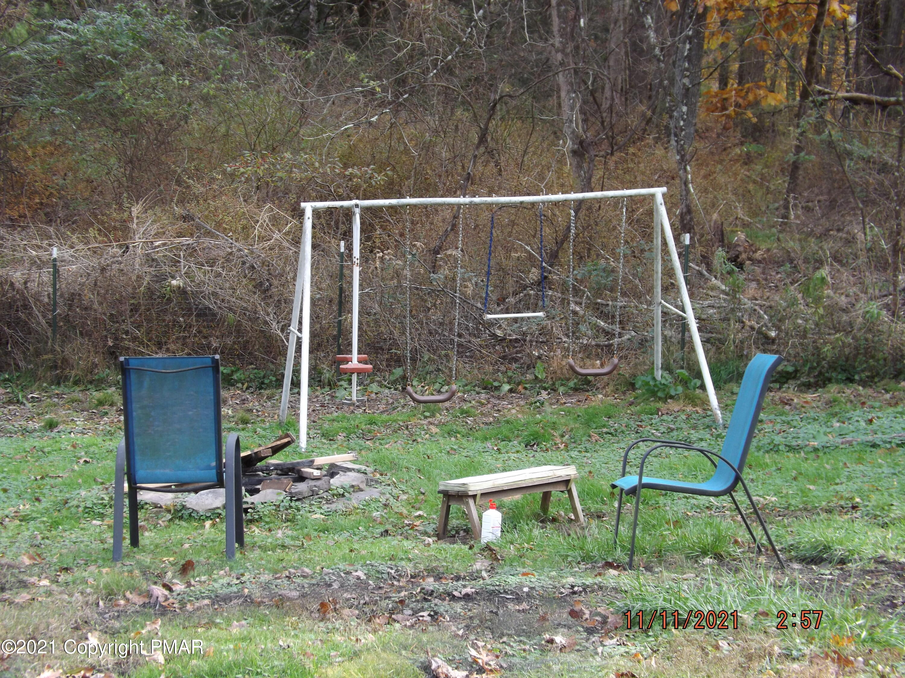 5474 Paradise Valley Road Cresco, PA 18326 - Photo 33 of 34 a view of a backyard with chairs potted plants and wooden fence