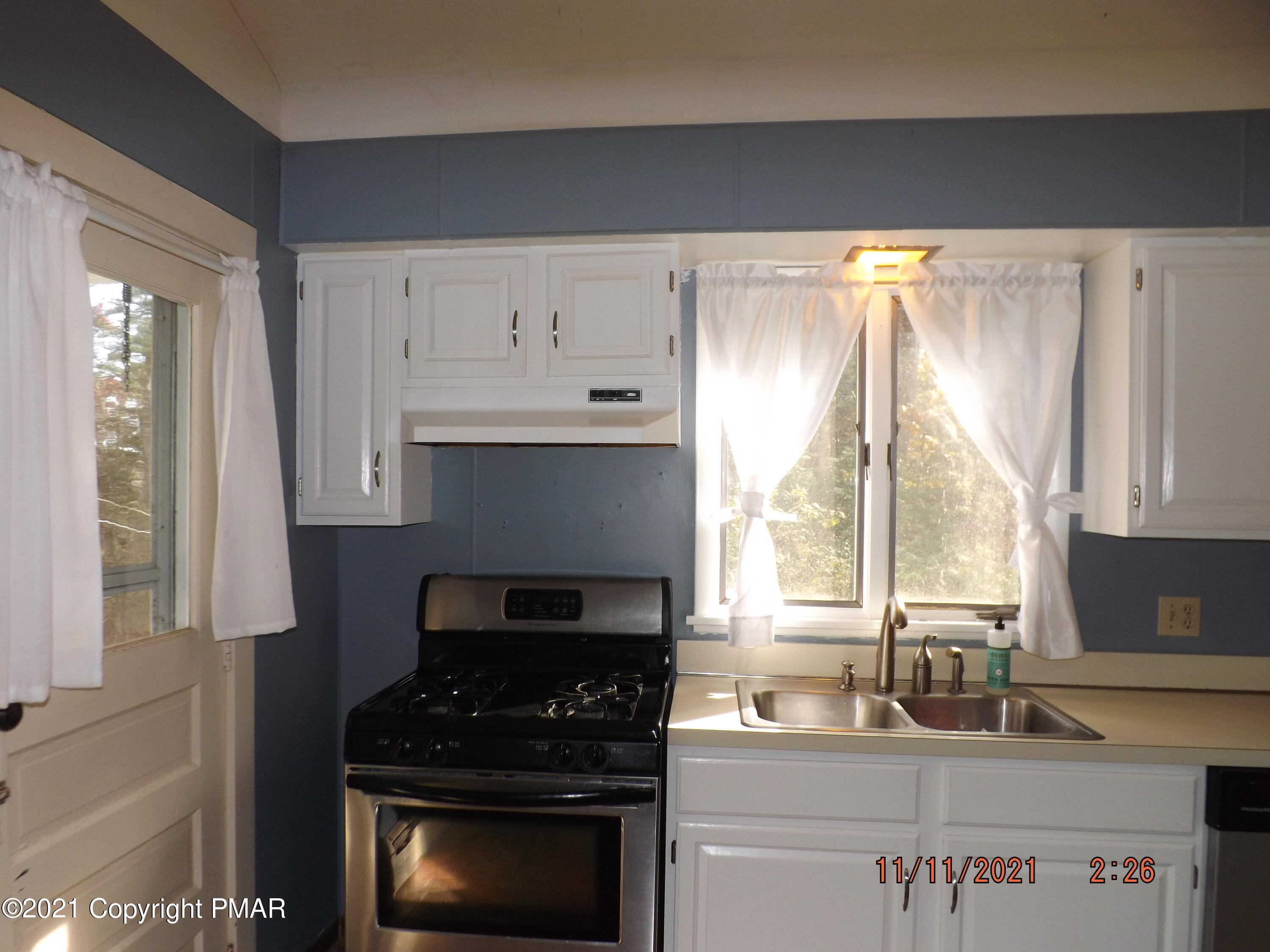 5474 Paradise Valley Road Cresco, PA 18326 - Photo 8 of 34 a kitchen with granite countertop a stove a sink and a white wooden cabinets
