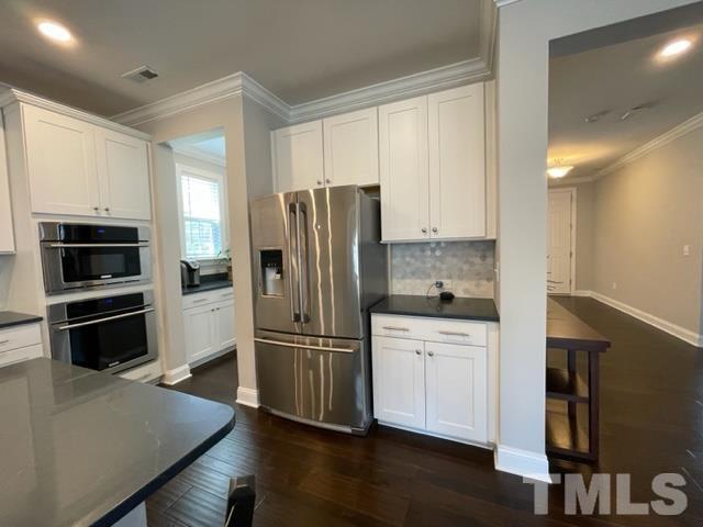 1425 Barn Door Drive Apex, NC 27502 - Photo 11 of 43 a kitchen with granite countertop a refrigerator and a stove top oven