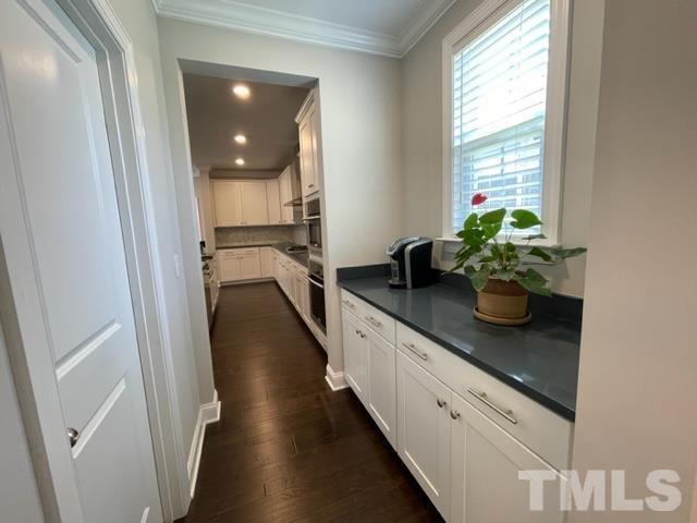 1425 Barn Door Drive Apex, NC 27502 - Photo 14 of 43 a hallway with white cabinets and potted plant