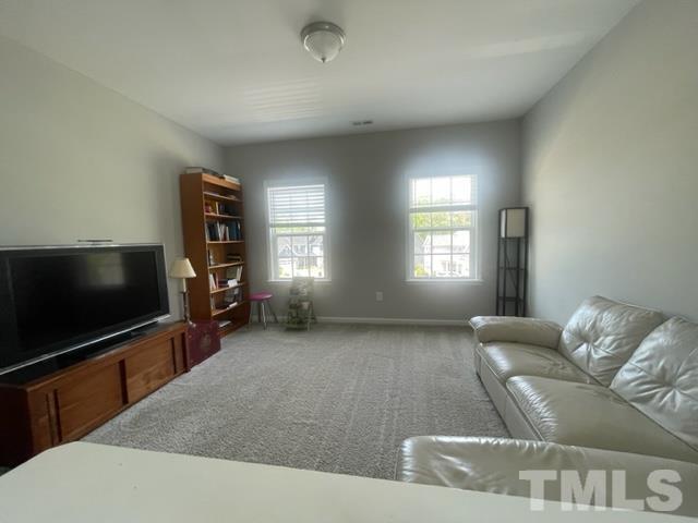 1425 Barn Door Drive Apex, NC 27502 - Photo 25 of 43 a living room with furniture and a flat screen tv