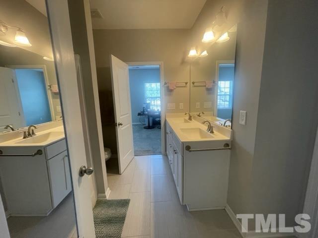 1425 Barn Door Drive Apex, NC 27502 - Photo 27 of 43 a bathroom with a sink a toilet and mirror