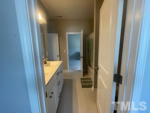 1425 Barn Door Drive Apex, NC 27502 - Photo 28 of 43 a bathroom with a sink and mirror with bathtub