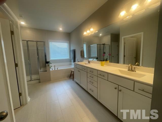 1425 Barn Door Drive Apex, NC 27502 - Photo 33 of 43 a bathroom with double vanity and a bathtub