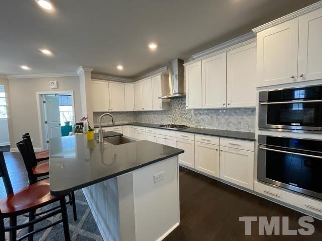 1425 Barn Door Drive Apex, NC 27502 - Photo 10 of 43 a kitchen with stainless steel appliances granite countertop a stove a sink a microwave a dining table and chairs
