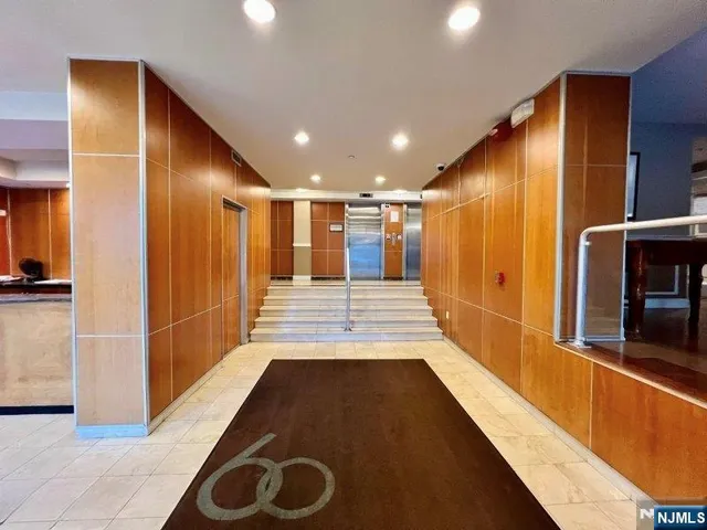 a view of a hallway with wooden floor and a bathroom