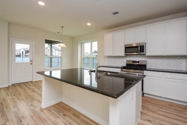 a kitchen with granite countertop a stove and a sink