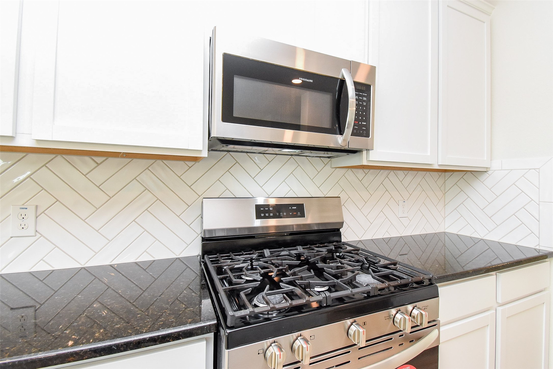32426 Fly Fish Way Fulshear, TX 77441 - Photo 15 of 32 a kitchen with a stove and a microwave