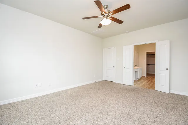 an empty room with a ceiling fan and a window