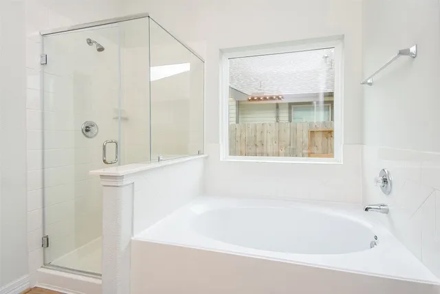a white bath tub sitting next to a shower
