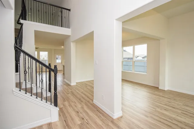 a view of a hallway with wooden floor and staircase