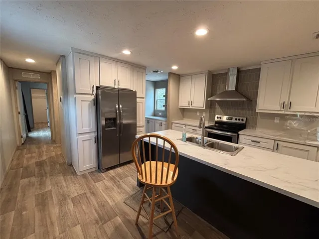 a kitchen with stainless steel appliances granite countertop a refrigerator stove microwave and sink