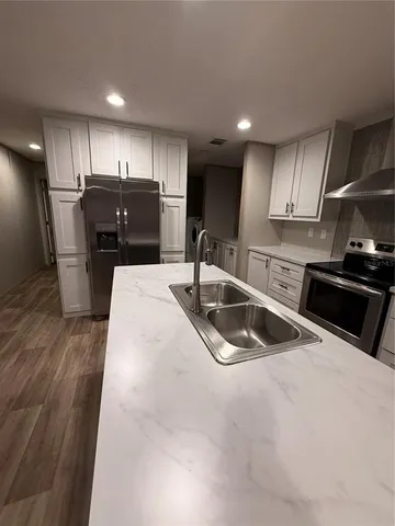 a kitchen with stainless steel appliances wooden cabinets a sink and a stove