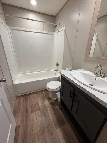 a bathroom with a sink a toilet a mirror and shower